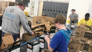 A team works together to package product.