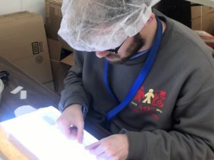 Employee uses a lightbox to build a product.