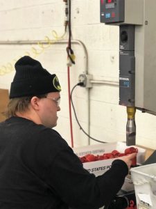 Employee uses a sonic welder to finsih building a product.