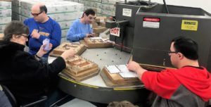 Employees working on a blister pack machine.